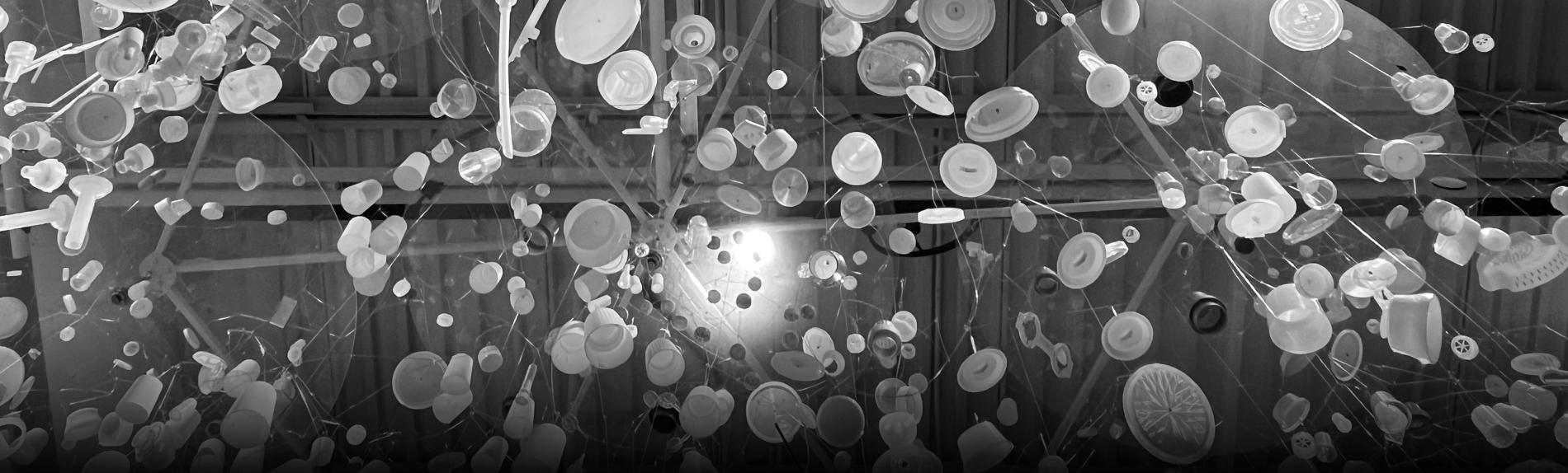 A grayscale photograph of various plastic objects being lit from the back