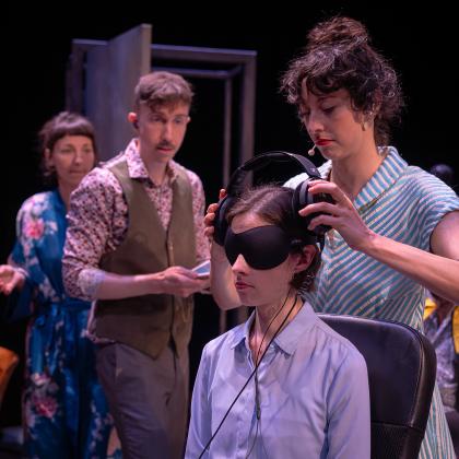 Une femme met des écouteurs à une autre femme qui porte un cache yeux.